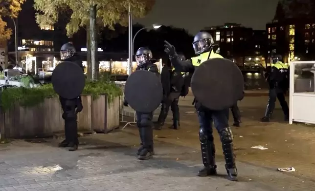 In this image taken from video, police officers patrol in riot gear on the streets of Amsterdam, Monday Nov. 11, 2024, as the city is facing tensions following violence last week. (AP Photo