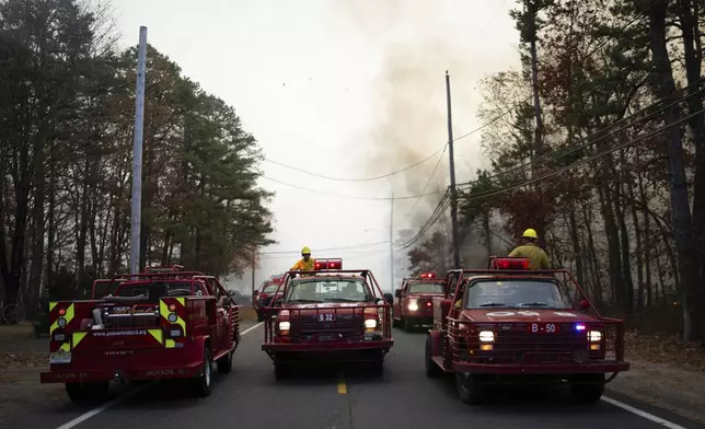 This photo provided by New Jersey Department of Environmental Protection firefighters respond to a forest fire on Wednesday, Nov. 6, 2024 in Evesham, N.J. (New Jersey Department of Environmental Protection via AP)