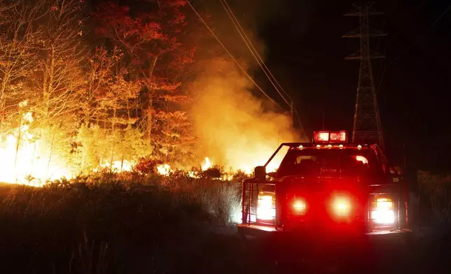 This photo provided by New Jersey Department of Environmental Protection firefighters respond to a forest fire on Wednesday, Nov. 6, 2024 in Evesham, N.J. (New Jersey Department of Environmental Protection via AP)