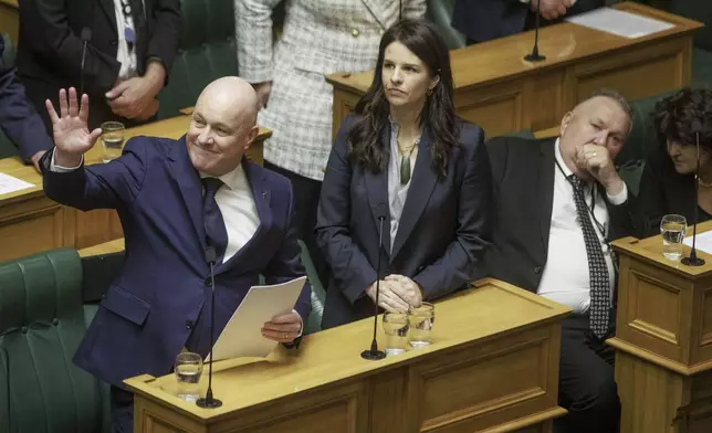 New Zealand's Prime Minister Christopher Luxon gestures to the public gallery as he makes a "formal and unreserved" apology in Parliament for the widespread abuse, torture and neglect of hundreds of thousands of children and vulnerable adults in care, in Wellington, New Zealand, Tuesday, Nov. 12, 2024. (Robert Kitchin/Stuff via AP)