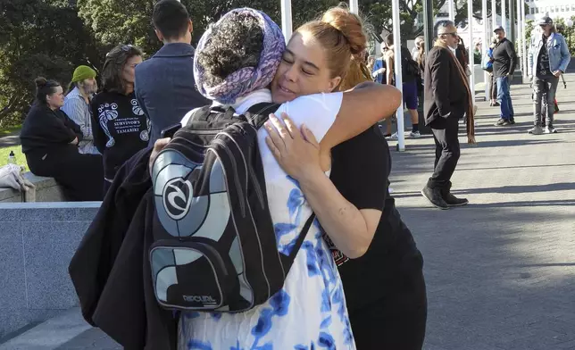 Two women embrace as they arrive at Parliament House in Wellington, New Zealand, ahead of the apology to the survivors of abuse in state, faith-based and foster care over a period of seven decades, Tuesday, Nov. 12, 2024. (AP Photo/Charlotte Graham-McLay )