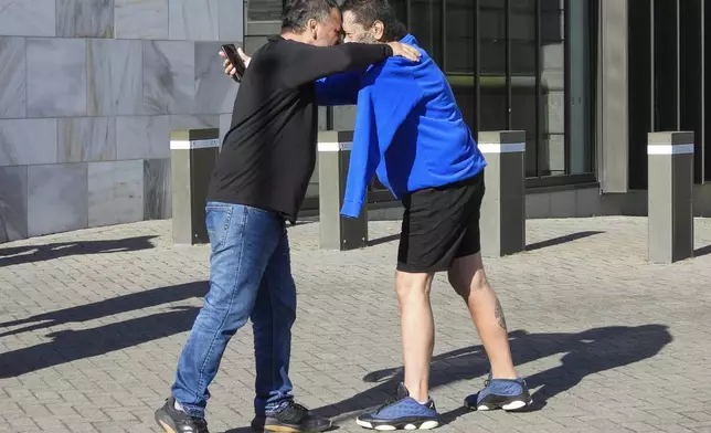 Two men great each other with a hongi, a Maori greeting, as they arrive at Parliament House in Wellington, New Zealand, ahead of the apology to the survivors of abuse in state, faith-based and foster care over a period of seven decades, Tuesday, Nov. 12, 2024. (AP Photo/Charlotte Graham-McLay )