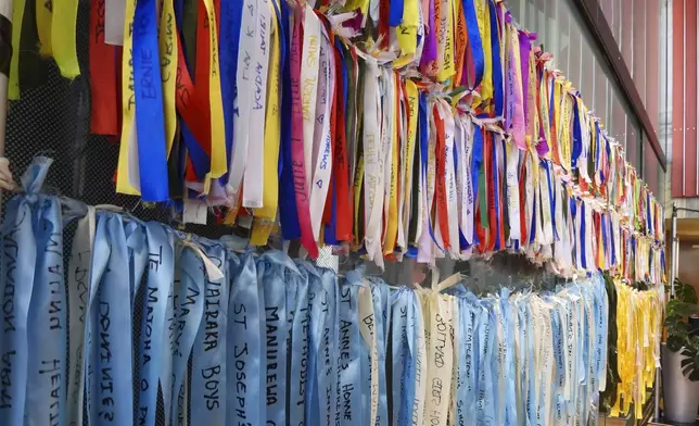 Ribbons are displayed on a wall at Parliament House in Wellington, New Zealand, ahead of the apology to the survivors of abuse in state, faith-based and foster care over a period of seven decades, Tuesday, Nov. 12, 2024. (AP Photo/Charlotte Graham-McLay )