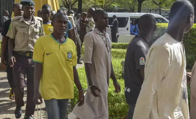 Children who had faced the death penalty for allegedly protesting against the country's cost of living crisis, are led to a courtroom in Abuja, Nigeria Tuesday, Nov. 5, 2024. (AP Photo/Olamikan Gbemiga)