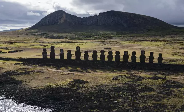 FILE - Moai statues stand on Ahu Tongariki near the Rano Raraku volcano, top, on Rapa Nui, or Easter Island, Chile, Nov. 27, 2022. (AP Photo/Esteban Felix, File)