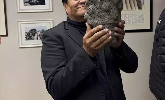 In this photo provided by the Kon-Tiki Museum press service on Wednesday, Nov. 13, 2024, a person holds an artifact taken from Easter Island, also known as Rapa Nui, by a Norwegian explorer in the late 1940s, during the "repatriation" ceremony at the Kon Tiki Museum in Oslo, Norway, Tuesday, Nov. 12, 2024. (Kon-Tiki Museum press service via AP)