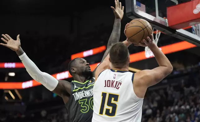 Denver Nuggets center Nikola Jokic (15) looks to take a shot as Minnesota Timberwolves forward Julius Randle (30) defends during the first half of an NBA basketball game, Friday, Nov. 1, 2024, in Minneapolis. (AP Photo/Abbie Parr)