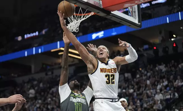 Denver Nuggets forward Aaron Gordon (32) goes up for a shot as Minnesota Timberwolves center Naz Reid (11) defends during the first half of an NBA basketball game, Friday, Nov. 1, 2024, in Minneapolis. (AP Photo/Abbie Parr)