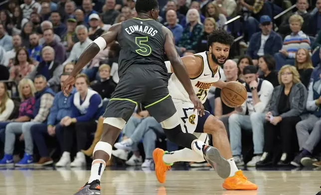 Denver Nuggets guard Jamal Murray (27) works toward the basket as Minnesota Timberwolves guard Anthony Edwards (5) defends during the first half of an NBA basketball game, Friday, Nov. 1, 2024, in Minneapolis. (AP Photo/Abbie Parr)