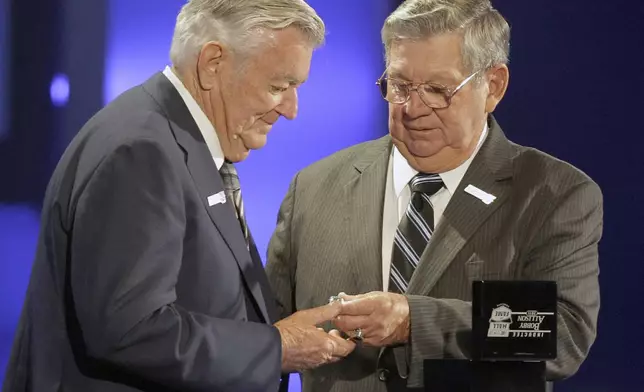 FILE - Bobby Allison, left, is given his ring by brother Donnie Allison, right, as he is inducted into the NASCAR Hall of Fame in Charlotte, N.C., Monday, May 23, 2011. (AP Photo/Chuck Burton, File)