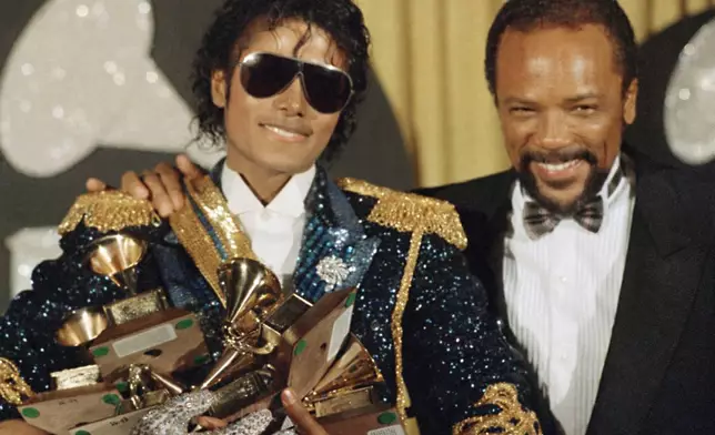 FILE - Michael Jackson, left, holds eight awards as he poses with Quincy Jones at the Grammy Awards in Los Angeles, Feb. 28, 1984. Quincy Jones died at age 91. (AP Photo/Doug Pizac, File)