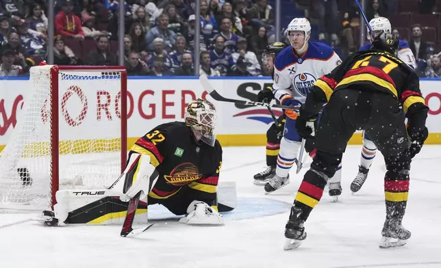 Edmonton Oilers' Corey Perry (90) scores against Vancouver Canucks goalie Kevin Lankinen (32) during the second of an NHL hockey game in Vancouver, on Saturday, Nov. 9, 2024. (Darryl Dyck/The Canadian Press via AP)