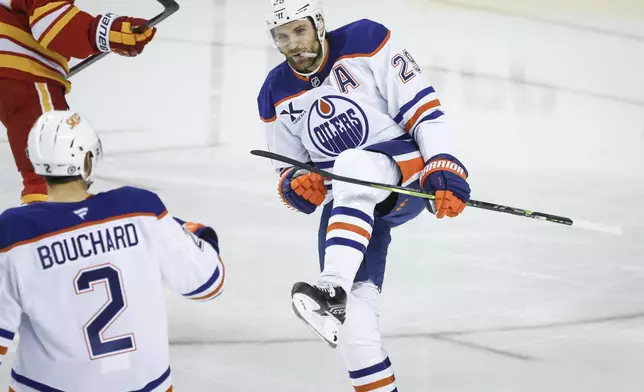 Edmonton Oilers' Leon Draisaitl, right, celebrates after his goal with teammate Evan Bouchard (2) during first-period NHL hockey game action against the Calgary Flames in Calgary, Alberta, Sunday, Nov. 3, 2024. (Jeff McIntosh/The Canadian Press via AP)