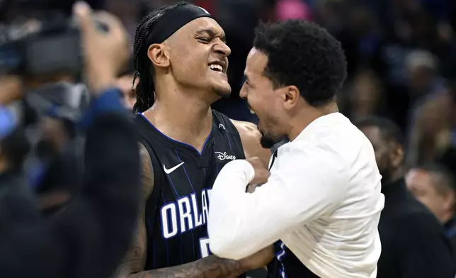 Orlando Magic forward Paolo Banchero, left, and guard Cole Anthony, right, celebrate after their win over the Indiana Pacers in an NBA basketball game, Monday, Oct. 28, 2024, in Orlando, Fla. (AP Photo/Phelan M. Ebenhack)