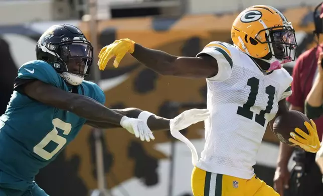 Green Bay Packers' Jayden Reed makes a first down catch in front of Jacksonville Jaguars' Darnell Savage during the second half of an NFL football game Sunday, Oct. 27, 2024, in Jacksonville, Fla. (AP Photo/John Bazemore)