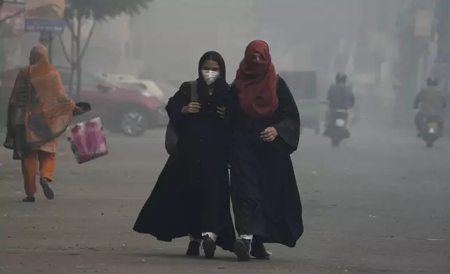 Students wear mask and heading to their school as smog envelops the areas of Lahore, Pakistan, Wednesday, Nov. 6, 2024. (AP Photo/K.M. Chaudary)