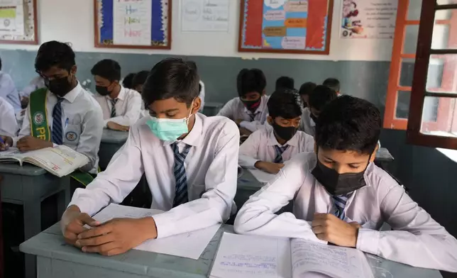 Students wear mask to protect themselves from poor air quality due to increasing smog in the city as they attend their school, in Lahore, Pakistan, Monday, Nov. 4, 2024. (AP Photo/K.M. Chaudary)