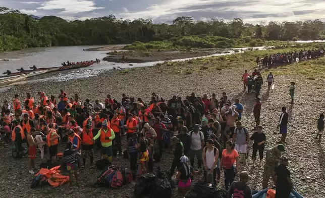 Migrants line up to board boats to continue their journey north hoping to reach the United States after walking across the Darien Gap from Colombia in Bajo Chiquito, Panama, Saturday, Nov. 9, 2024. (AP Photo/Matias Delacroix)