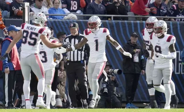 New England Patriots wide receiver Ja'Lynn Polk (1) celebrates his touchdown reception with tight end Hunter Henry during the first half of an NFL football game against the Chicago Bears on Sunday, Nov. 10, 2024, in Chicago. (AP Photo/Nam Y. Huh)