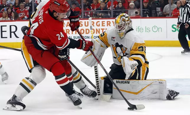 Carolina Hurricanes' Seth Jarvis (24) tries to maintain control of the puck near Pittsburgh Penguins goaltender Alex Nedeljkovic (39) during the second period of an NHL hockey game in Raleigh, N.C., Thursday, Nov. 7, 2024. (AP Photo/Karl B DeBlaker)