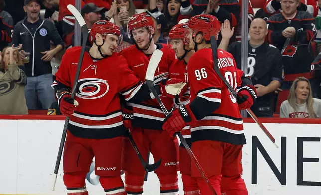 Carolina Hurricanes' Jack Roslovic (96) celebrates his goal with teammates Dmitry Orlov, left, Andrei Svechnikov, second left, and Sebastian Aho (20) during the second period of an NHL hockey game in Raleigh, N.C., Thursday, Nov. 7, 2024. (AP Photo/Karl B DeBlaker)