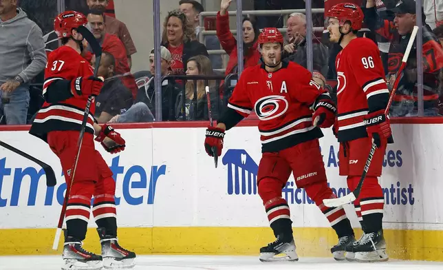 Carolina Hurricanes' Jack Roslovic (96) is congratulated on his goal by teammates Sebastian Aho (20) and Andrei Svechnikov (37) during the first period of an NHL hockey game against the Pittsburgh Penguins in Raleigh, N.C., Thursday, Nov. 7, 2024. (AP Photo/Karl B DeBlaker)