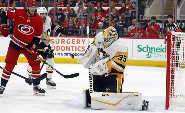 Pittsburgh Penguins goaltender Alex Nedeljkovic (39) blocks a shot as teammate Kris Letang (58) battles with Carolina Hurricanes' Andrei Svechnikov (37) during the second period of an NHL hockey game in Raleigh, N.C., Thursday, Nov. 7, 2024. (AP Photo/Karl B DeBlaker)