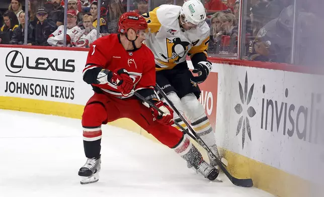 Carolina Hurricanes' Dmitry Orlov (7) checks Pittsburgh Penguins' Evgeni Malkin (71) during the first period of an NHL hockey game in Raleigh, N.C., Thursday, Nov. 7, 2024. (AP Photo/Karl B DeBlaker)