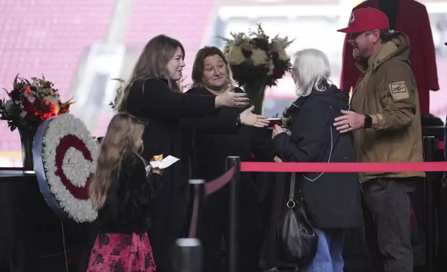 Kara, second from left, and Fawn Rose, center, both daughters of Cincinnati Reds legend Pete Rose, meet baseball fans during a public visitation, Sunday, Nov. 10, 2024, at Great American Ball Park in Cincinnati. (AP Photo/Kareem Elgazzar)