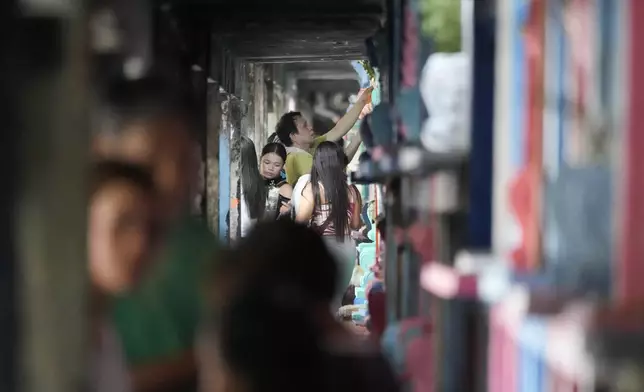 People visit apartment-type tombs of their departed loved ones in at a crowded Manila's North Cemetery, Philippines as the nation observes All Saints Day on Friday, Nov. 1, 2024. (AP Photo/Aaron Favila)