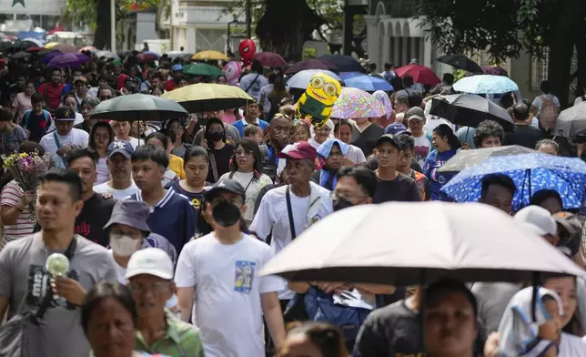 People make their way at a crowded Manila's North Cemetery, Philippines as the nation observes All Saints Day on Friday, Nov. 1, 2024. (AP Photo/Aaron Favila)