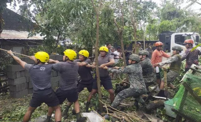 In this photo provided by the Provincial Disaster Risk Reduction and Management Office Cagayan, soldiers and rescuers help clear an area from debris and toppled trees caused by Typhoon Yinxing in Sanchez Mira, Cagayan province, northern Philippines Friday Nov. 8, 2024. (Provincial Disaster Risk Reduction and Management Office, Cagayan via AP)