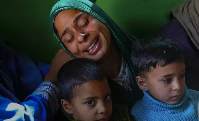 Gulshan Begum grieves holding her sons Rihan Zahhor, right and Arhan Zahoor, during the funeral of her husband Zahoor Ahmad, an army porter who was among those killed in a rebel ambush on an army vehicle previous night, in Boniyar, north of Srinagar, Indian controlled Kashmir, Friday, Oct. 25, 2024. (AP Photo/Dar Yasin)