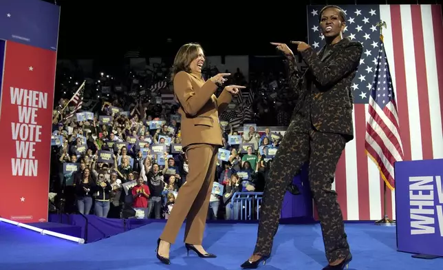 Democratic presidential nominee Vice President Kamala Harris, left, and former first lady Michelle Obama arrive to speak during a campaign rally at the Wings Event Center in Kalamazoo, Mich. (AP Photo/Jacquelyn Martin)