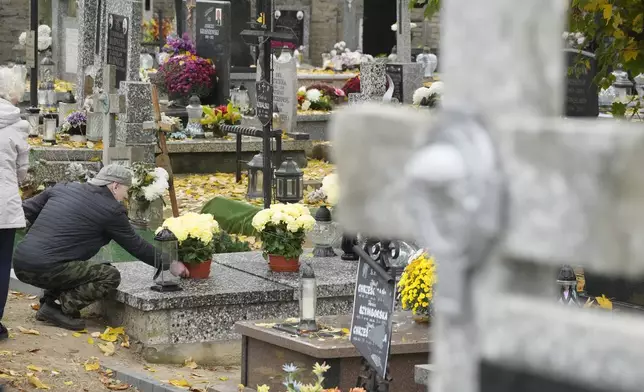 People prepare for All Saints' Day at the cemetery in Zakroczym, near Warsaw, Poland, Wednesday, Oct. 30, 2024. (AP Photo/Czarek Sokolowski)