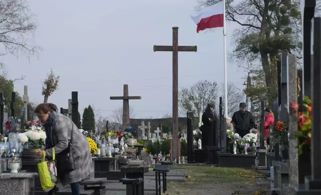 People observe All Saints' Day, a time for reflecting on those who have died, in Zakroczym near Warsaw, Poland, Friday Nov. 1, 2024. (AP Photo/Czarek Sokolowski)