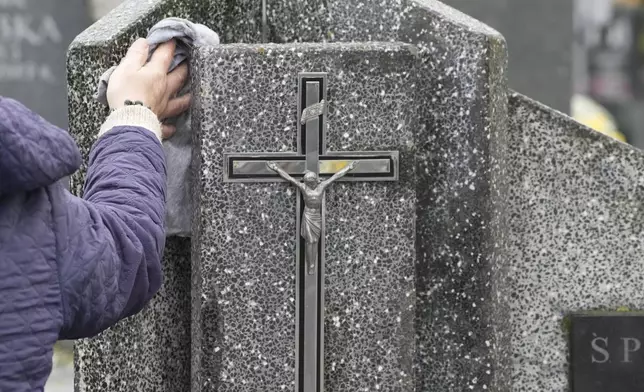 People prepare for All Saints' Day at the cemetery in Zakroczym, near Warsaw, Poland, Wednesday, Oct. 30, 2024. (AP Photo/Czarek Sokolowski)