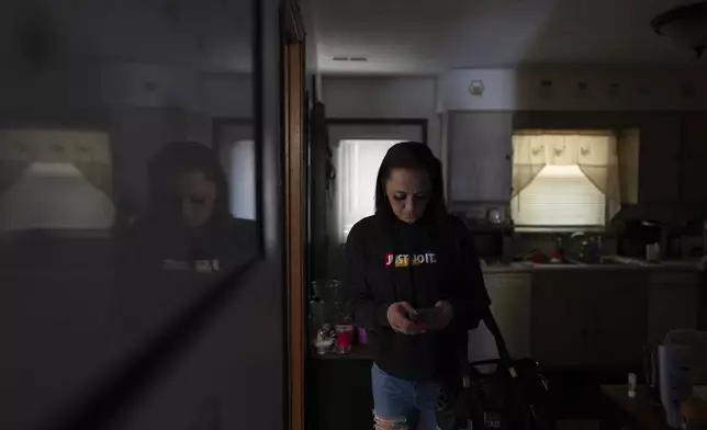 April Youst looks at her phone as she prepares to leave her West Virginia home on Wednesday, Oct. 9, 2024. (AP Photo/Carolyn Kaster)