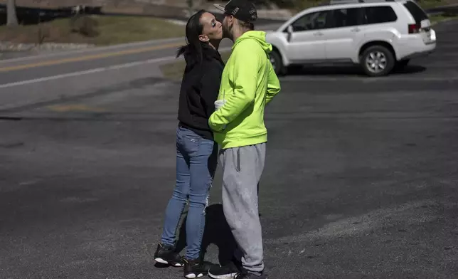 April Youst kisses Aaron Parsons in the parking lot before starting work at a restaurant in West Virginia on Wednesday, Oct. 9, 2024. (AP Photo/Carolyn Kaster)