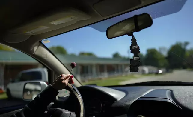 April Youst holds a grape lollipop as she drives in West Virginia on Wednesday, Oct. 9, 2024. (AP Photo/Carolyn Kaster)