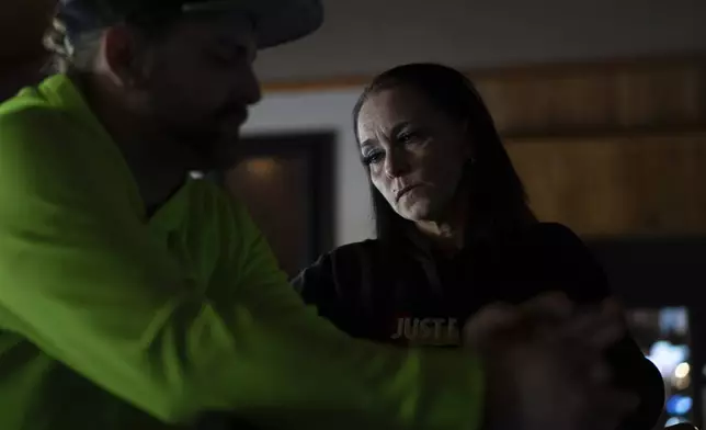 April Youst pauses as she talks with Aaron Parsons before starting work at a restaurant in West Virginia on Wednesday, Oct. 9, 2024. (AP Photo/Carolyn Kaster)