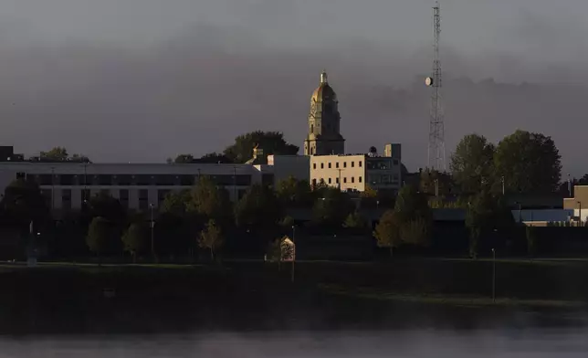 A light fog floats around the Cabell County Courthouse at sunrise in Huntington, W. Va. across the Ohio River from Chesapeake, Ohio, Thursday, Oct. 10, 2024. (AP Photo/Carolyn Kaster)