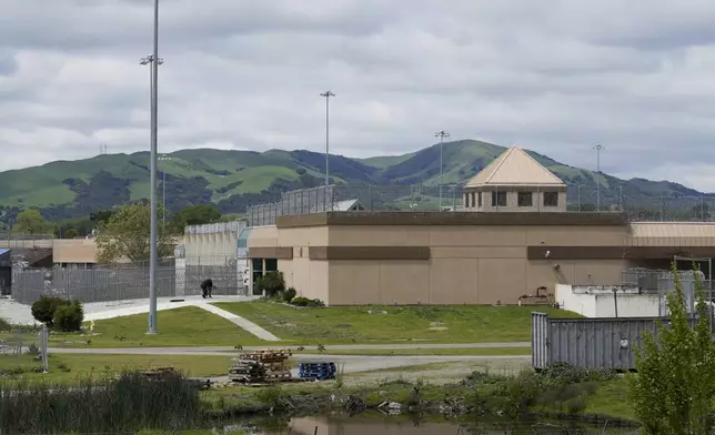 FILE - Two men walk into the Federal Correctional Institution in Dublin, Calif., Monday, April 15, 2024. (AP Photo/Terry Chea, File)