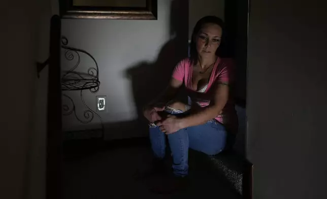 April Youst looks out from the top of the stairs in her West Virginia home on Wednesday, Oct. 9, 2024. (AP Photo/Carolyn Kaster)