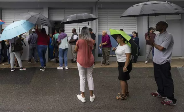 Voters line up at a polling station during general elections in San Juan, Puerto Rico, Tuesday, Nov. 5, 2024. (AP Photo/Alejandro Granadillo)