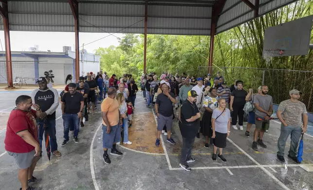 Voters line up at a polling station during general elections in San Juan, Puerto Rico, Tuesday, Nov. 5, 2024. (AP Photo/Alejandro Granadillo)