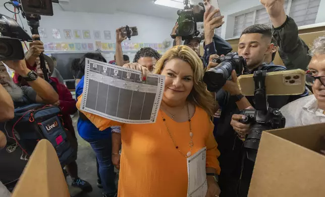 Jenniffer González, Puerto Rico's New Progressive Party candidate for Governor, shows her ballot during general elections in San Juan, Puerto Rico, Tuesday, Nov. 5, 2024. (AP Photo/Alejandro Granadillo)