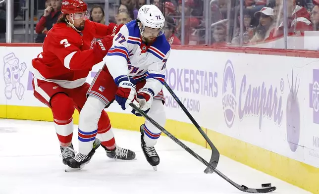 Detroit Red Wings defenseman Justin Holl (3) pursues New York Rangers center Filip Chytil (72) behind the net during the second period of an NHL hockey game Saturday, Nov. 9, 2024, in Detroit. (AP Photo/Duane Burleson)