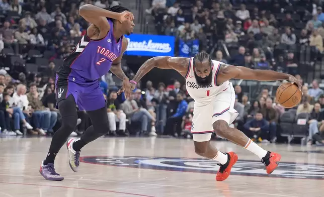 Los Angeles Clippers guard James Harden (1) is defended by Toronto Raptors forward Jonathan Mogbo (2) during the first half of an NBA basketball game Saturday, Nov. 9, 2024, in Inglewood, Calif. (AP Photo/Marcio Jose Sanchez)