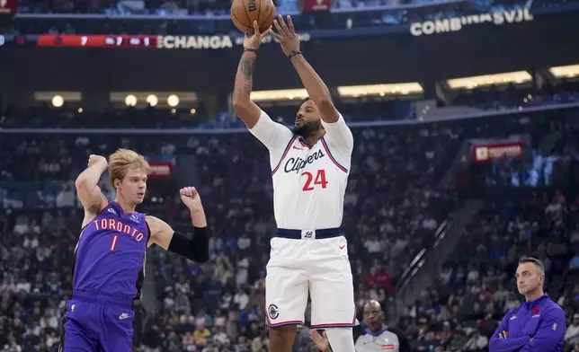 Los Angeles Clippers guard Norman Powell (24) shoots over Toronto Raptors guard Gradey Dick (1) during the first half of an NBA basketball game Saturday, Nov. 9, 2024, in Inglewood, Calif. (AP Photo/Marcio Jose Sanchez)